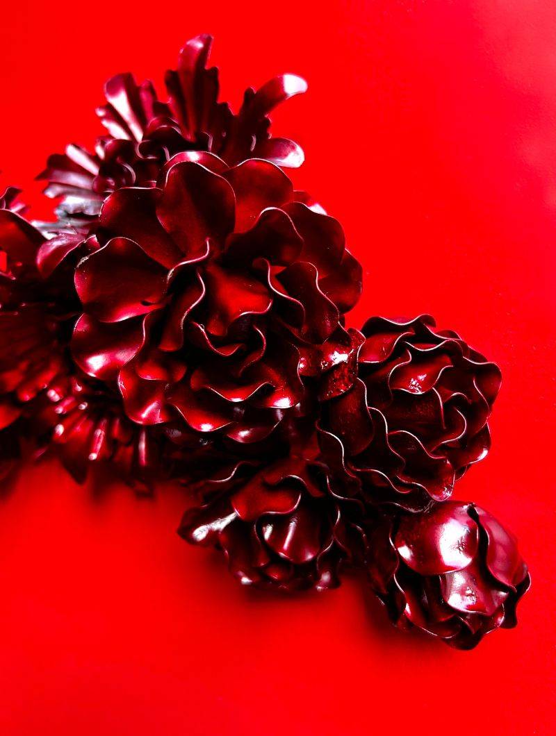 Metal sculpture in the form of a red flower wreath by Yasemen Hussein